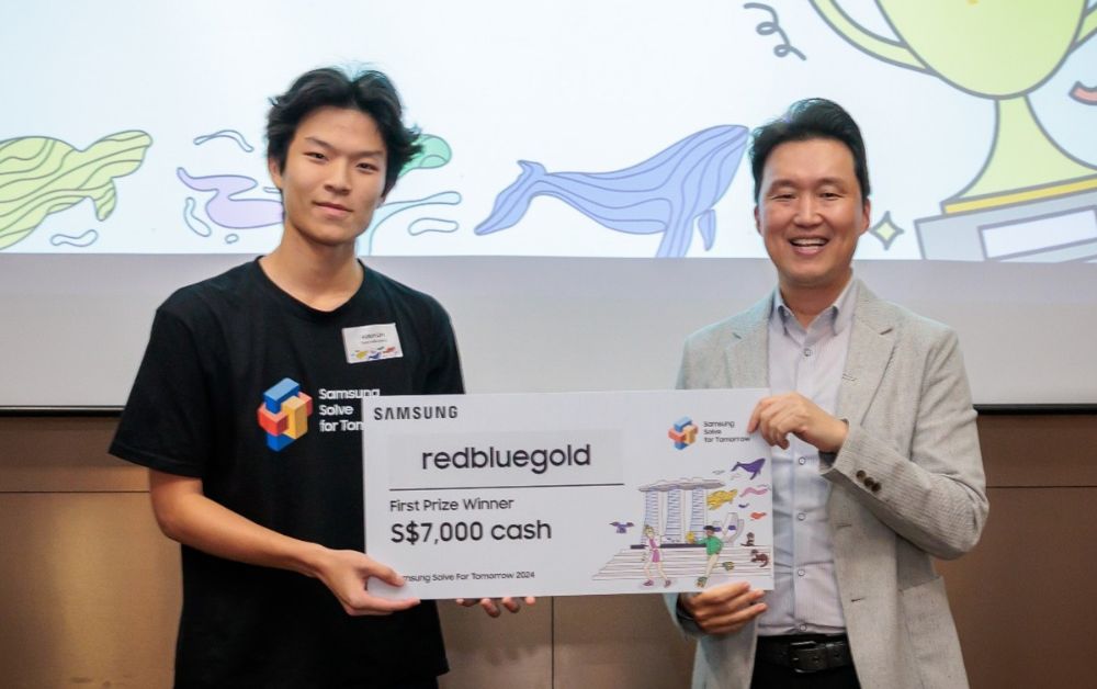 Team redbluegold’s Aiden Lim (left), receiving the prize from Dennis Jang, President, Samsung Electronics Singapore (right), as the grand winner of Samsung Solve for Tomorrow 2024 in Singapore